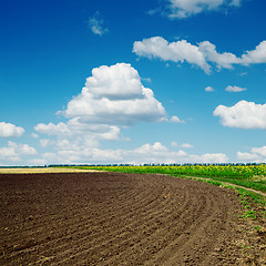 Image showing black plowed field and clouds in blue sky