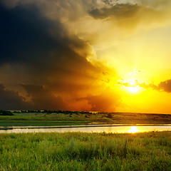 Image showing dramatic orange sunset over river