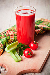 Image showing tomato juice in glass, fresh tomatoes and green celery