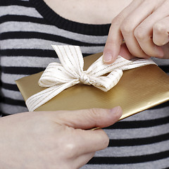 Image showing Young woman holding a present