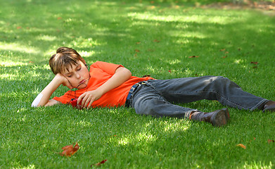 Image showing Boy in park listening to mp3 player