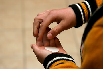 Image showing Boy holding a communion bead