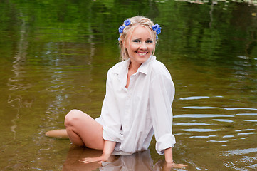 Image showing Happy young female sitting in the water