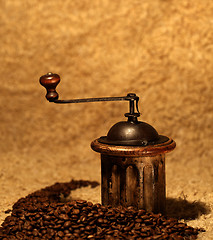 Image showing coffee grinder behind many brown beans