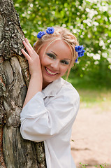 Image showing Smiling female in wreath near the tree