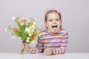 Image showing Girl with a bouquet of flowers sitting at table