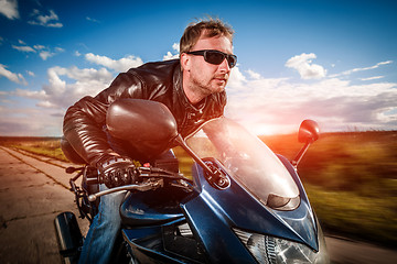 Image showing Biker racing on the road