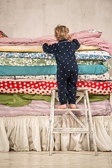 Image showing Child climbs on the bed - Princess and the Pea.