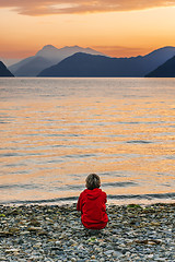 Image showing Woman enjoying beautiful sunset landscape on fjord