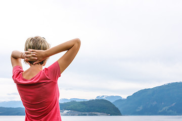 Image showing Back view of a woman enjoying a view at fjord