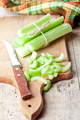 Image showing bundle of fresh green celery stems and knife