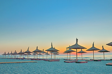 Image showing wicker beach umbrellas on the beach