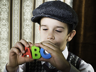 Image showing Child in vintage clothes hold letters a b c