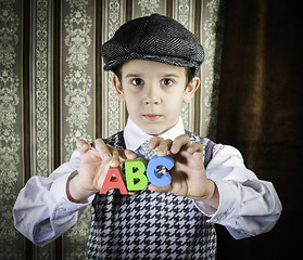 Image showing Child in vintage clothes hold letters a b c