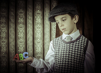 Image showing Child in vintage clothes hold letters a b c