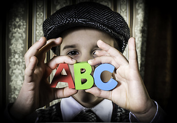 Image showing Child in vintage clothes hold letters a b c