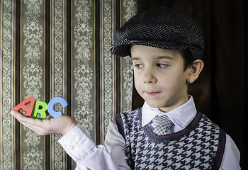 Image showing Child in vintage clothes hold letters a b c