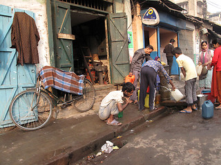 Image showing Streets of Kolkata. People filling up water in cans