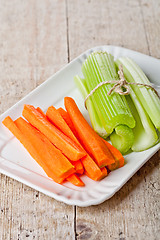 Image showing bundle of fresh green celery stems and carrot 