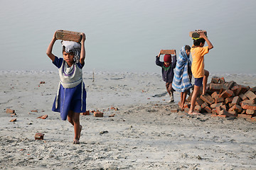 Image showing Child workers carry bricks carrying it on his head in Sonakhali, West Bengal, India