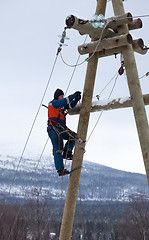 Image showing Electricians working on a pole in winter 