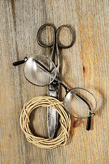 Image showing old scissors, glasses and hank of packthread on wooden backgroun