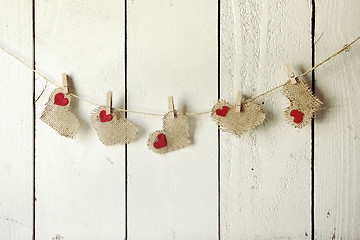 Image showing Happy Valentine Burlap Hearts Hanging on a Wood Wall