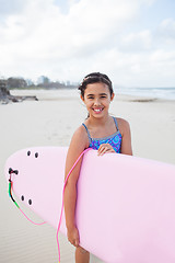 Image showing Happy young girl with surfboard