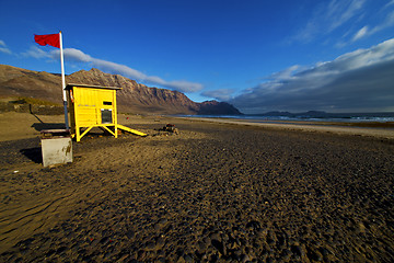 Image showing lifeguard chair red flag in sp  rock stone sky cloud beach  