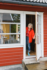 Image showing Woman looking out of a cabin door