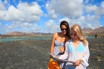 Image showing Two young attractive women with land map in summer holiday outdo