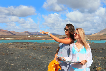 Image showing Two young attractive women with land map in summer holiday outdo