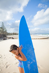 Image showing Happy young girl with surfboard at beach