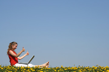 Image showing Smiling girl with laptop, thumbs up