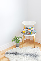 Image showing Chair with bright cushion and sheepskin rug on the floor