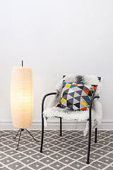 Image showing Chair with bright cushion and elegant floor lamp