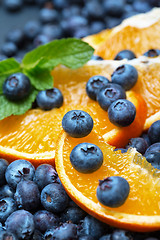 Image showing Freshly picked blueberries with orange