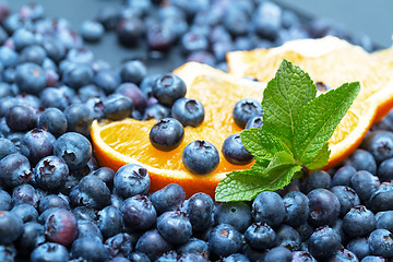 Image showing Freshly picked blueberries with orange