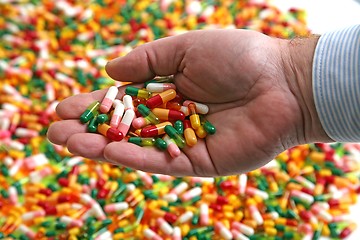 Image showing Hands full of medication pill capsules