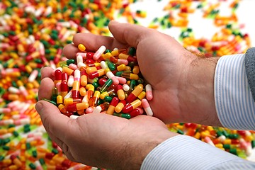 Image showing Hands full of medication pill capsules