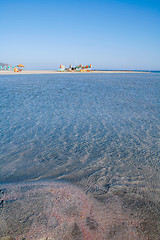 Image showing Red sand clear seas and beach umbrellas