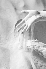 Image showing Sand slipping through fingers black and white