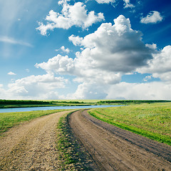 Image showing rural road in green grass and cloudy sky