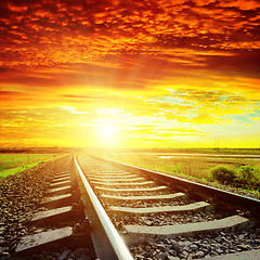 Image showing sunset with red clouds and railroad to horizon