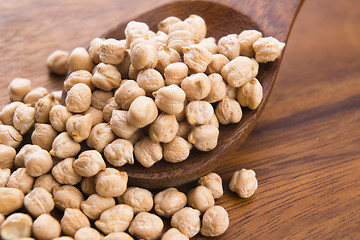 Image showing dried white chickpeas ceci on the wooden spoon