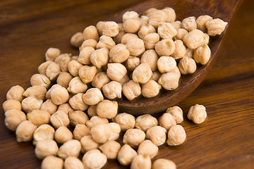 Image showing dried white chickpeas ceci on the wooden spoon