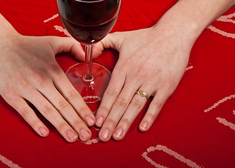 Image showing Scandinavian cute young girl hands shaping a heart and wine glas