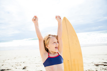 Image showing Happy young girl with surfboard on beach