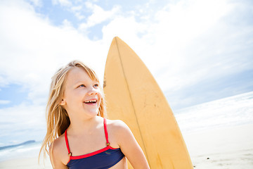 Image showing Happy young girl with surfboard at beach