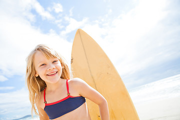 Image showing Happy young girl with surfboard at beach